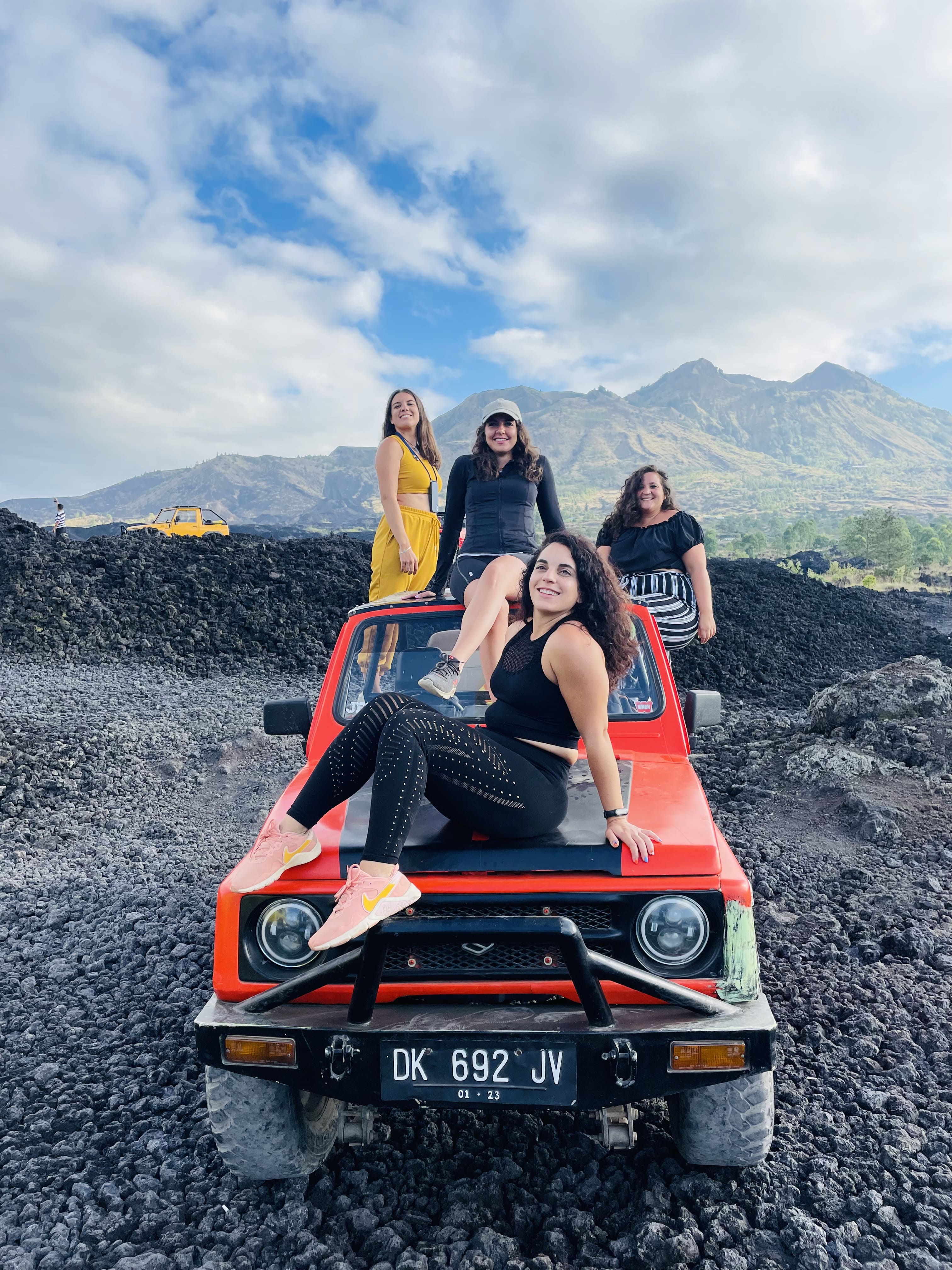Jeep on a volcanic track with the Batur caldera behind it in the early morning