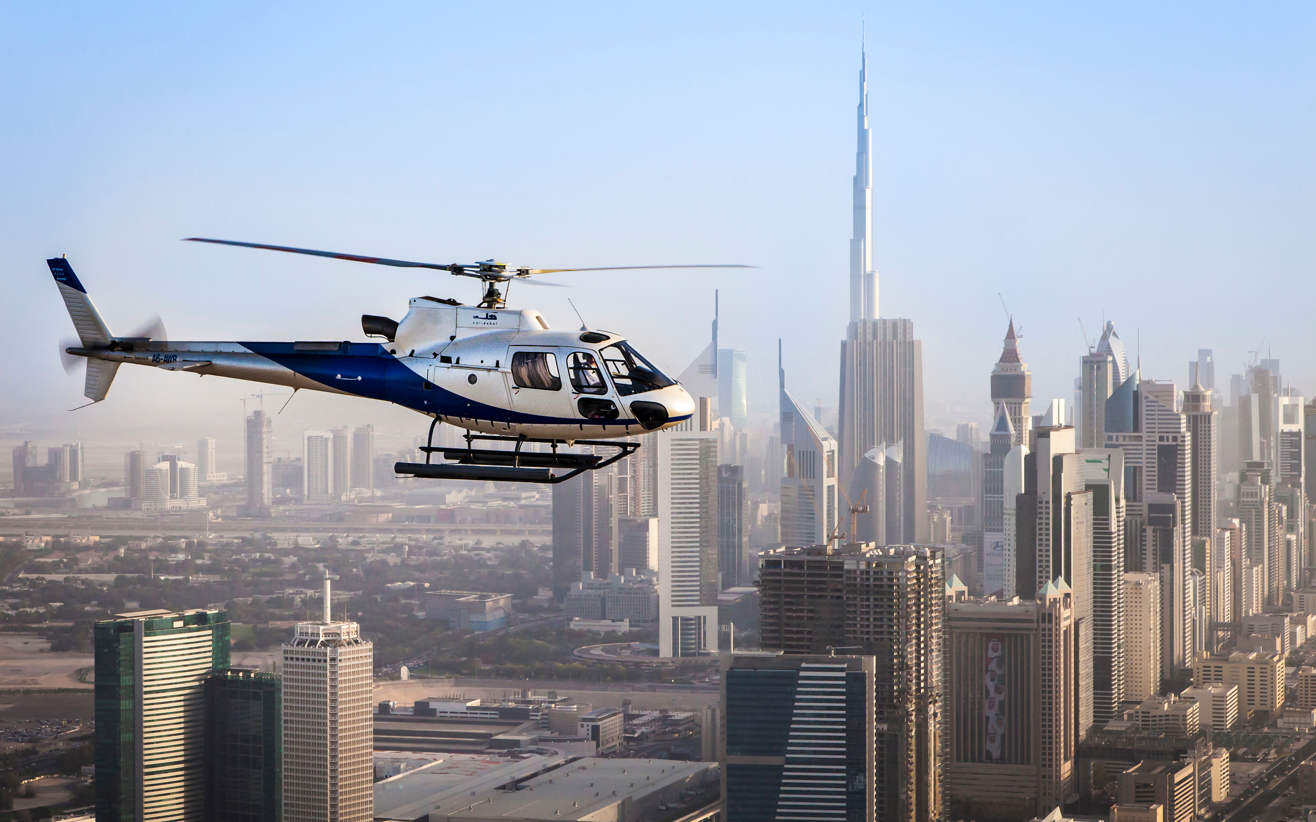 Helicopter flying past the Burj Khalifa and the towers lining Sheikh Zayed Road
