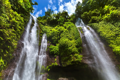 Sekumpul Waterfall pouring down a green jungle cliff in the hills of north Bali
