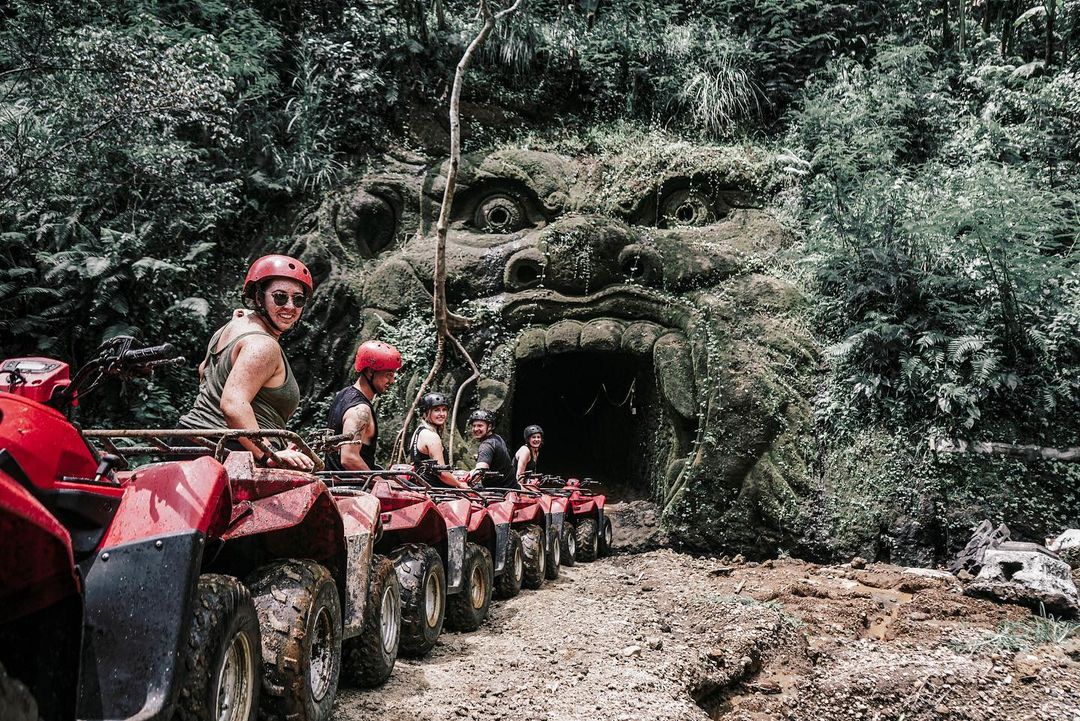 Riders on ATV quad bikes on a muddy jungle trail near Ubud