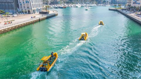 Yellow inflatable speedboat carrying passengers along the Dubai coastline
