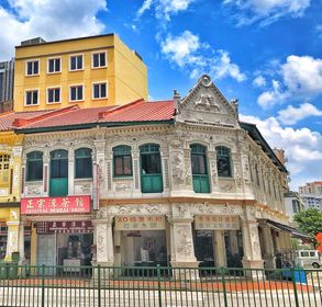 Ornate pre-war shophouses with green shutters and a red tiled roof on Balestier Road