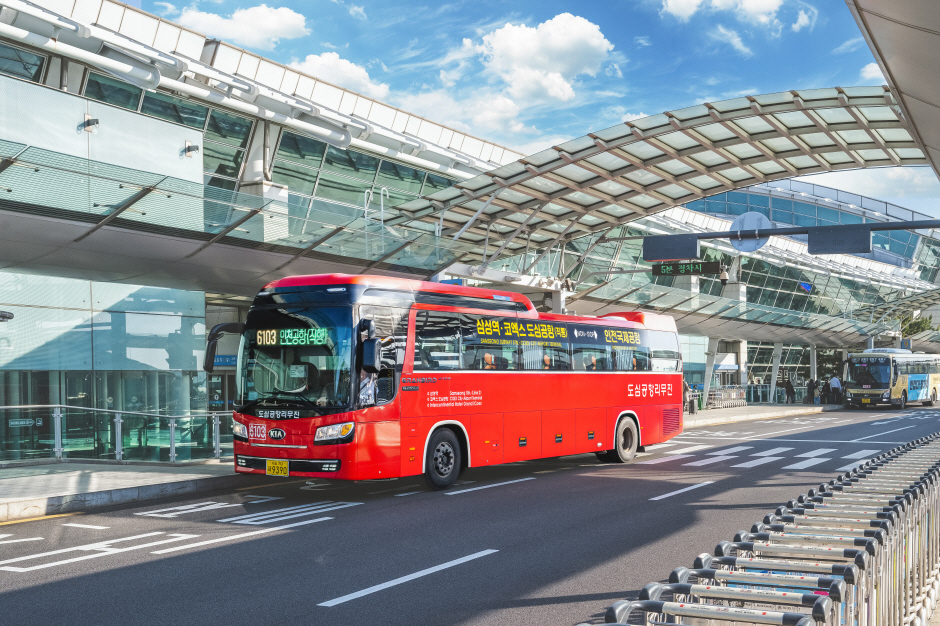 Red 6103 airport limousine bus waiting at the kerb outside a glass passenger terminal at Incheon Airport