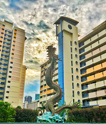 Dragon sculpture standing in front of public housing blocks near Whampoa