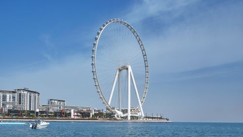 The Ain Dubai observation wheel on Bluewaters Island seen from the sea, with a small boat in front